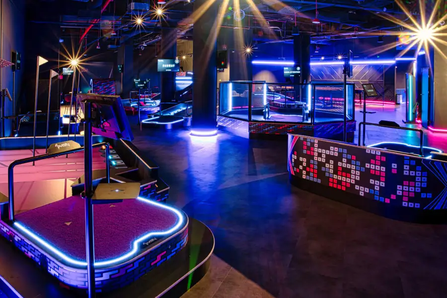 Neonowa sala Sky Games z torami minigolfa Sky Golf i strefami gier w niebieskim świetle